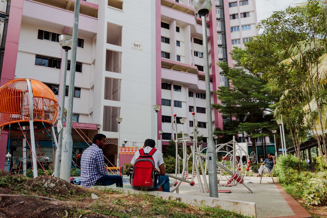 A couple of people sitting on the ground in front of a building